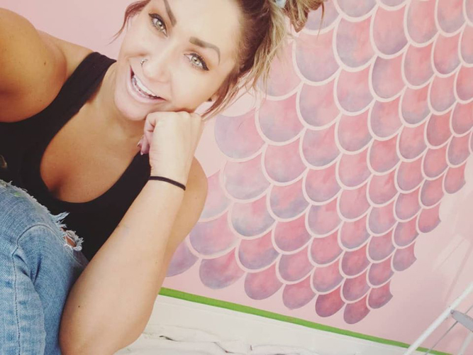 Selfie in front of custom painted mural, hand painted bedroom decals.